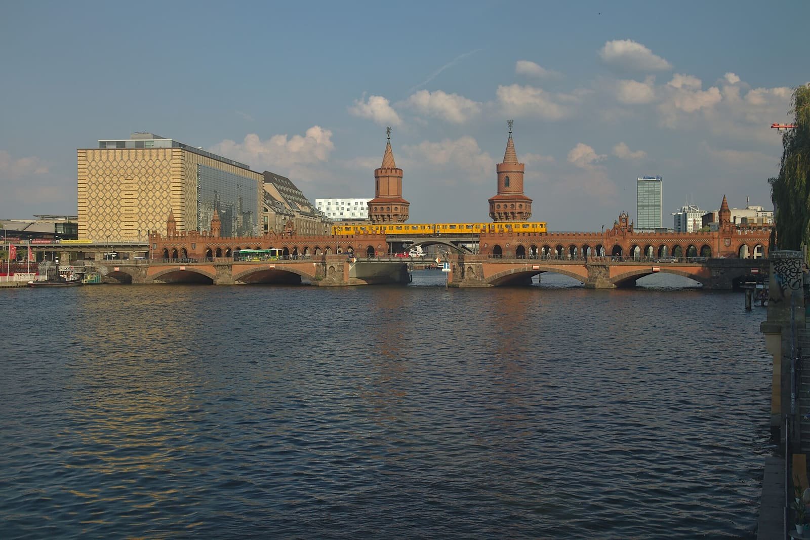 Red-brick double-deck bridge with towers spanning the Spree river