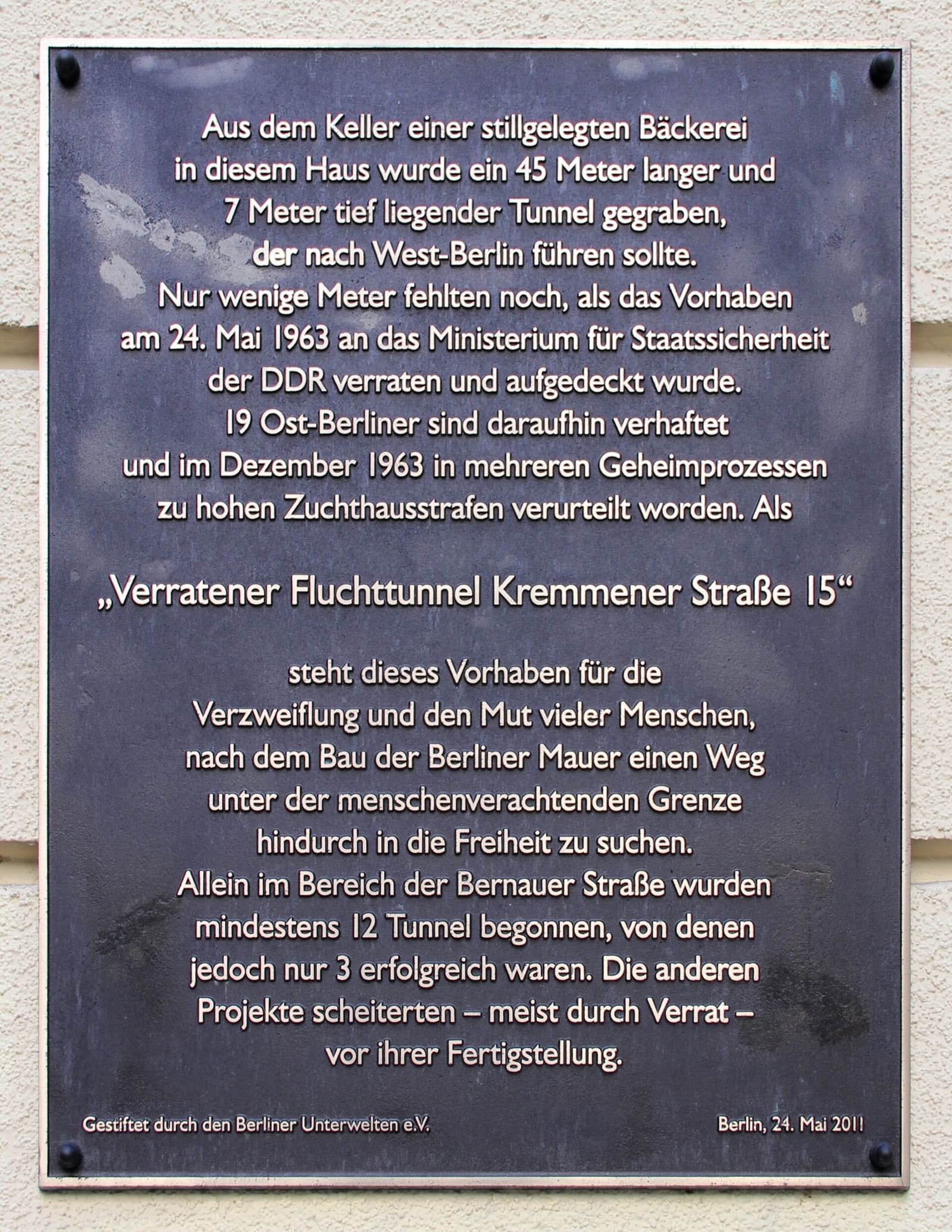 A plaque on a house wall headed 'Verratener Fluchttunnel'.