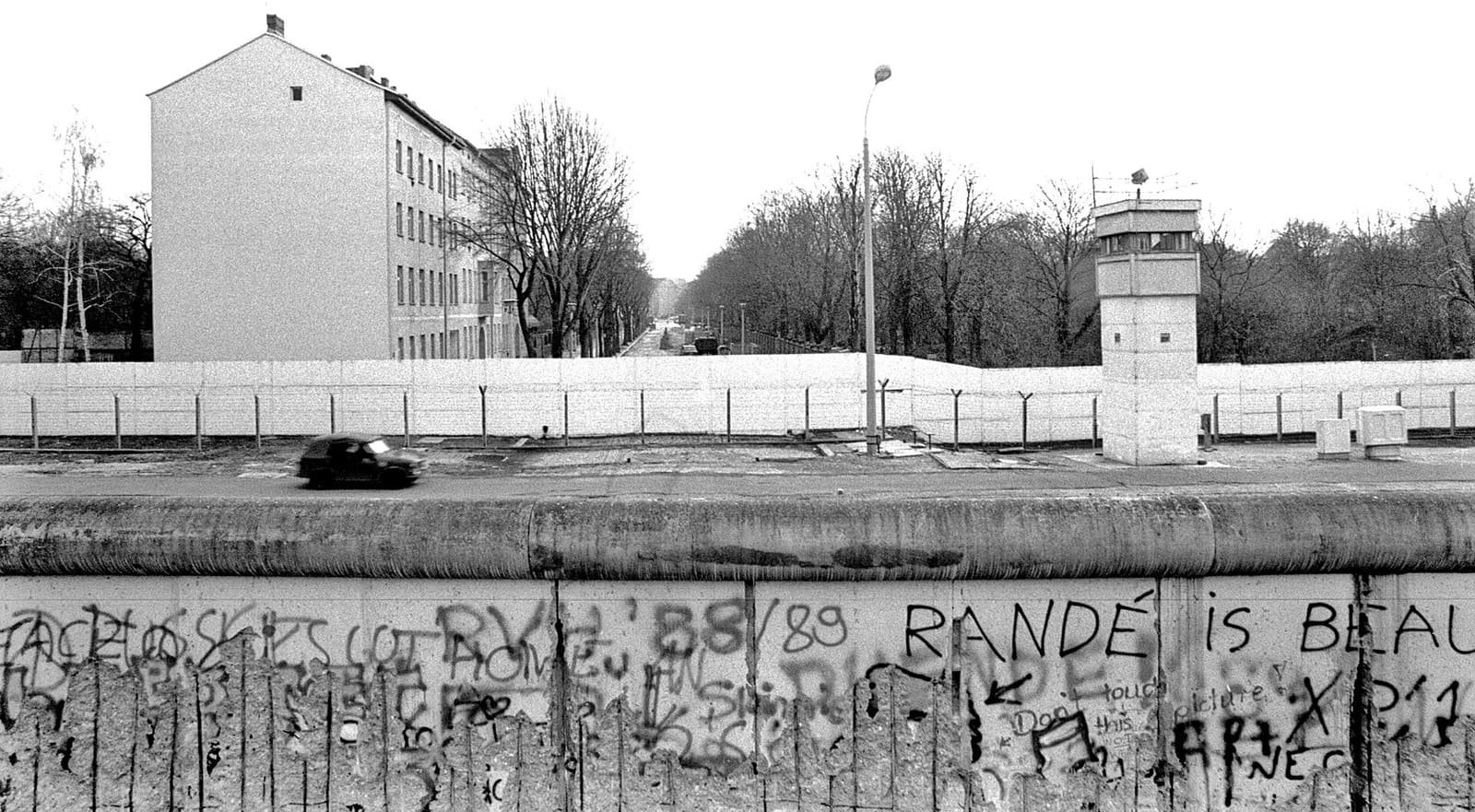 View of the death strip with a watchtower and a small military vehicle inside the border installations