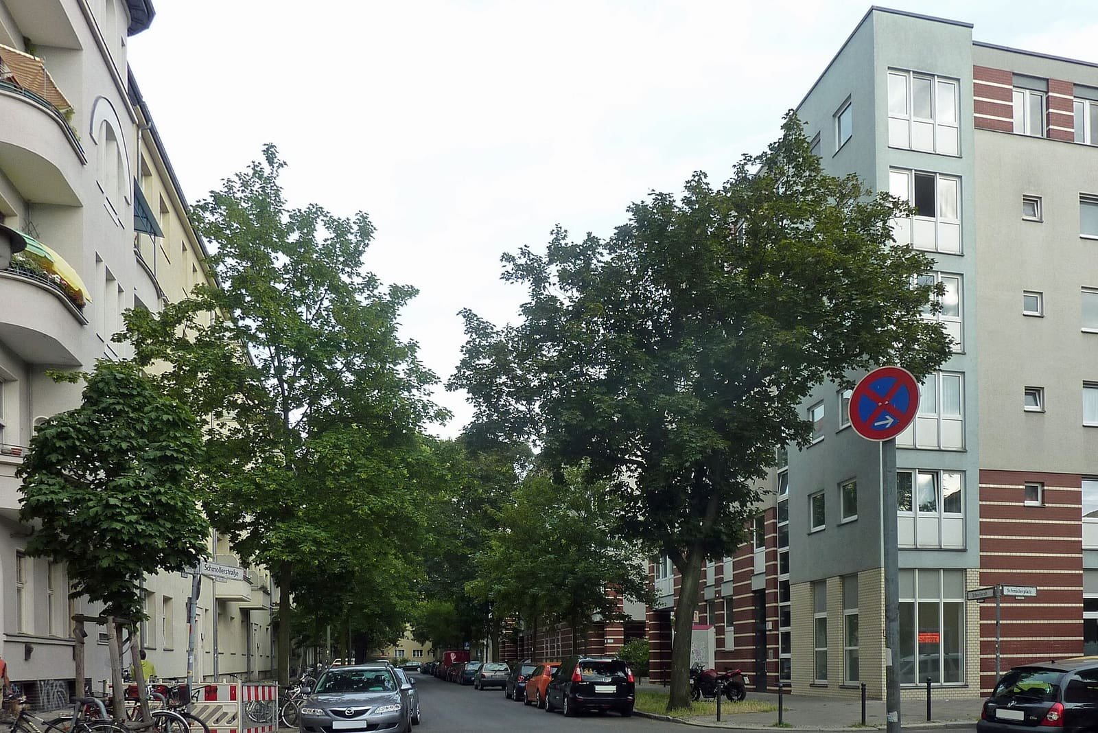 A residential street with apartment buildings and trees in Alt-Treptow.