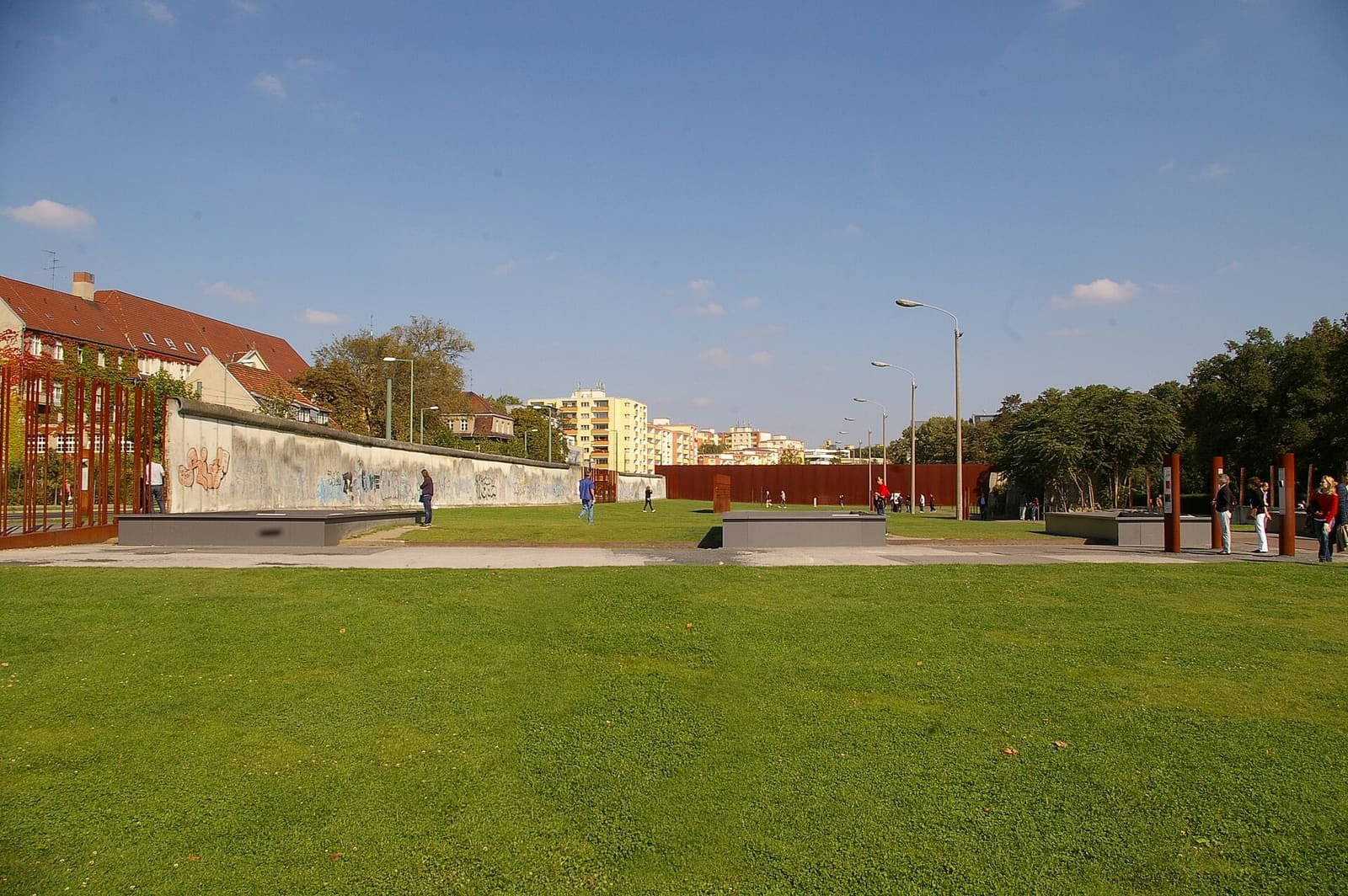 A preserved section of the border strip with the Wall and a watchtower, seen from a street corner