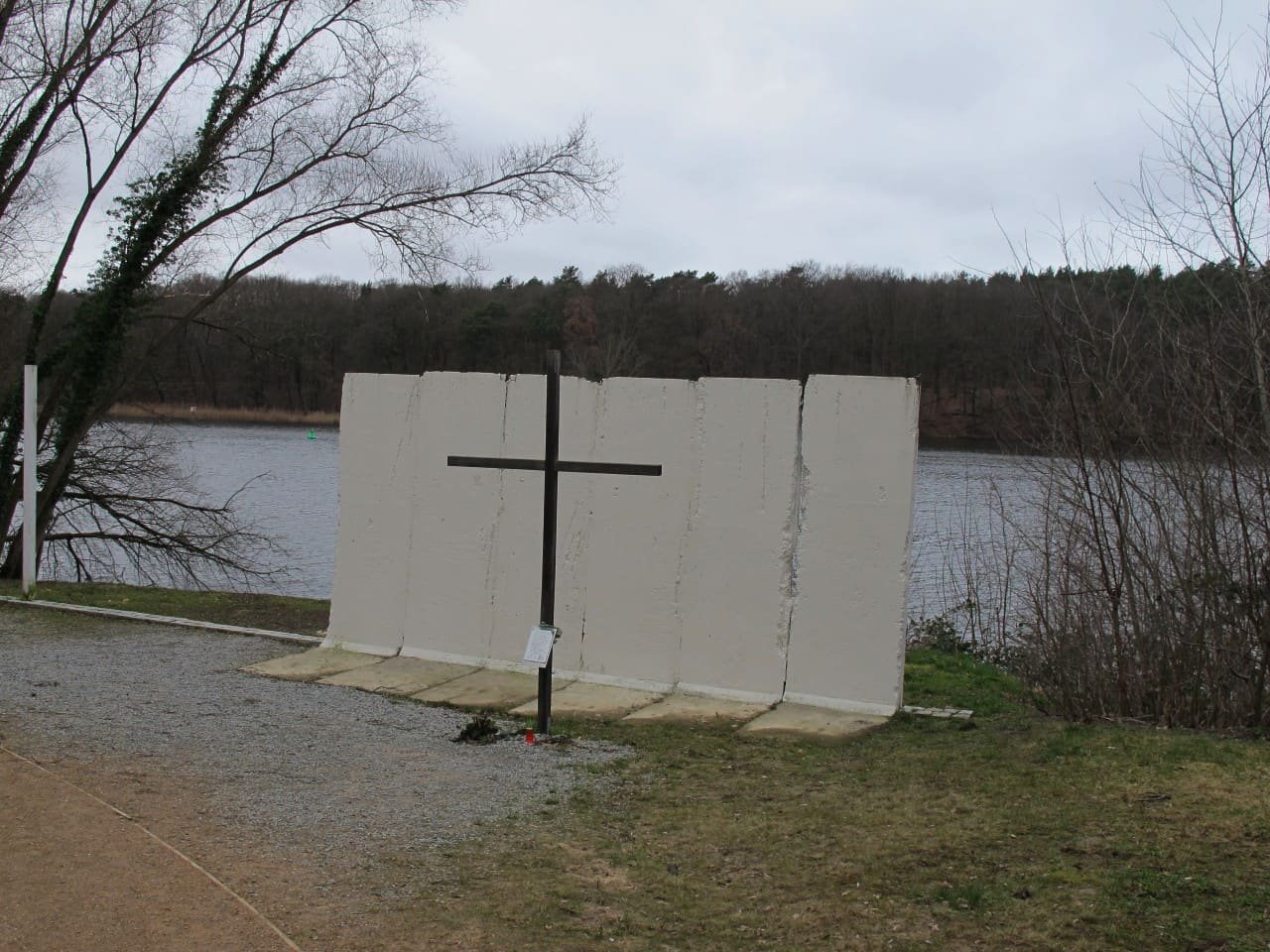 A line of markers along a path showing where the Wall once ran beside a lake