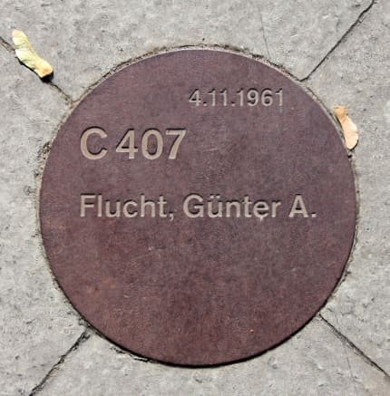 A small memorial plaque with text mounted outdoors