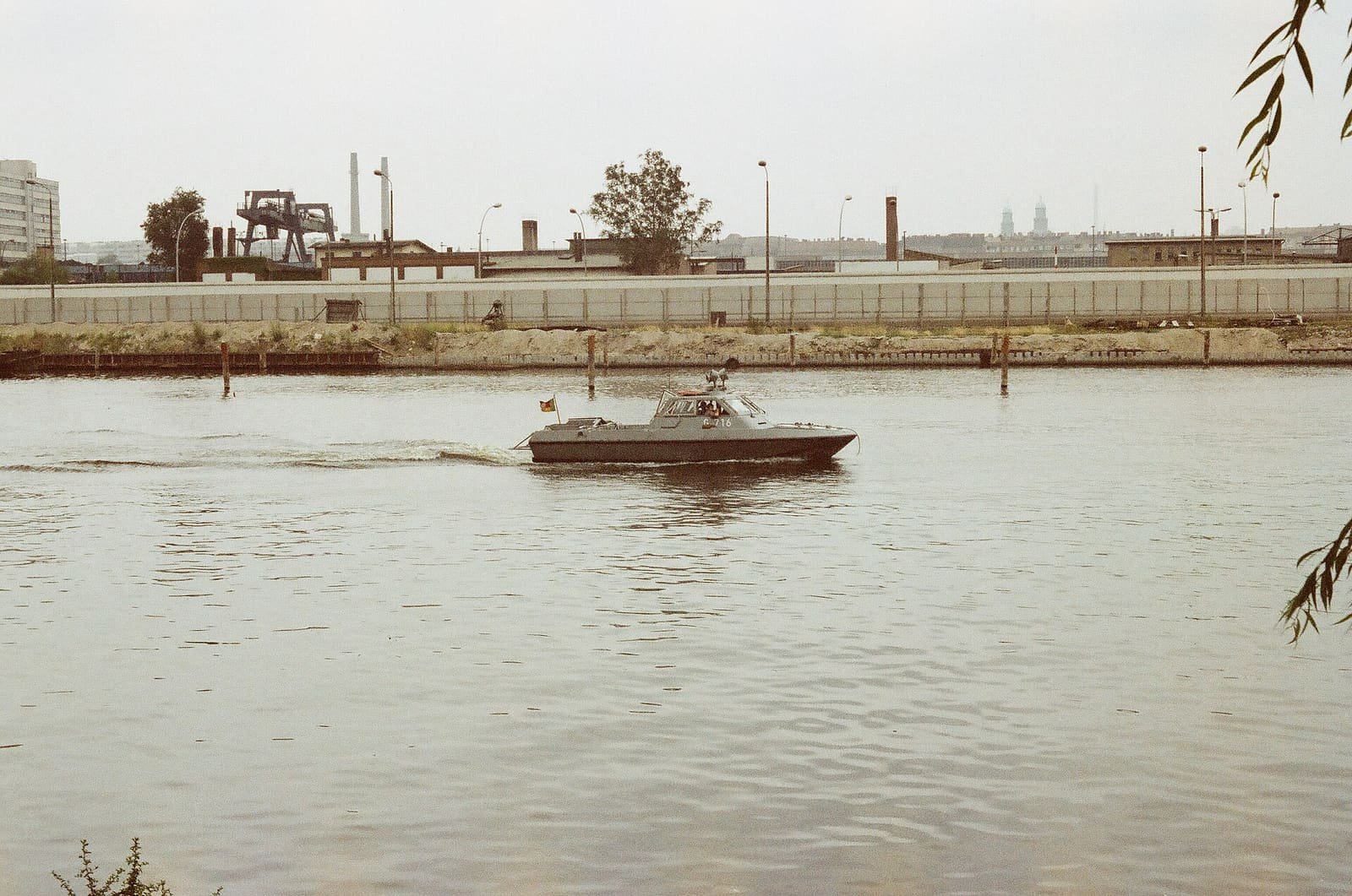 The brick Oberbaumbrücke spanning the Spree, with East German border patrol boats on the water, photographed in 1987.