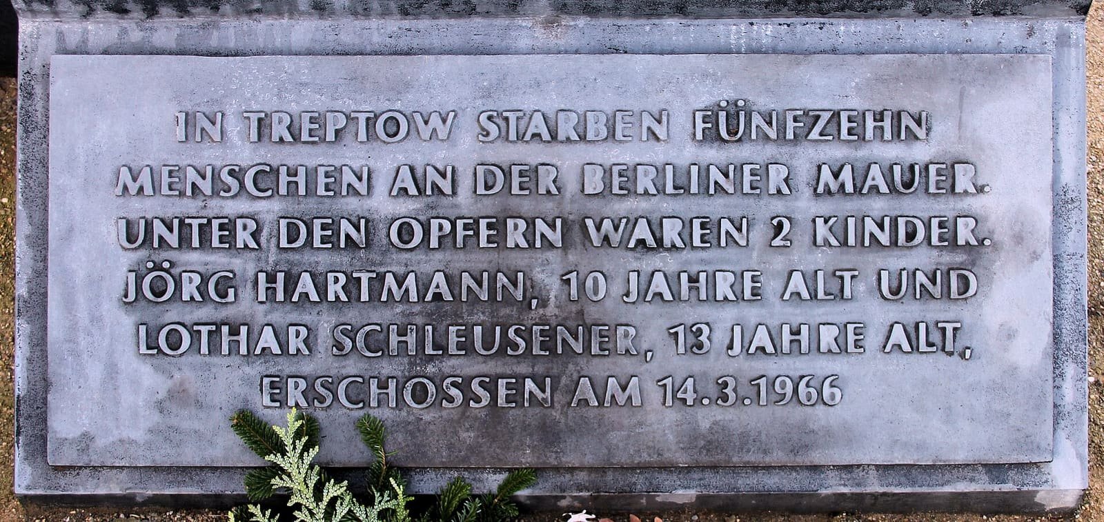 A horizontal memorial inscription naming Jörg Hartmann and Lothar Schleusener