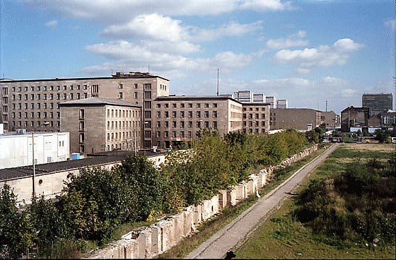 The Berlin Wall in the foreground with a large government building behind it.